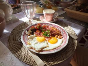 a plate of food with eggs and beans on a table at Bed&Breakfast Wagner "im Alten Pfarrhaus" in Neuruppin