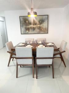 a dining room table with chairs and a painting on the wall at Suite Jacarandas 103 in Guadalajara