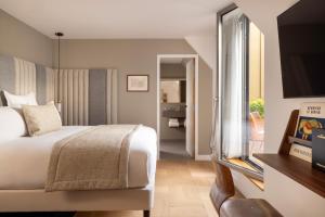 a hotel room with a bed and a flat screen tv at Hôtel Pilgrim in Paris