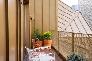 a balcony with two chairs and plants on it at Hôtel Pilgrim in Paris