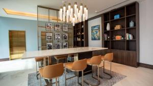 - une cuisine avec un bar avec des chaises et une table dans l'établissement Courtyard by Marriott Santo Domingo Piantini, à Saint-Domingue