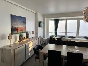 een woonkamer met een bank en een tafel bij Novo panoramic sea view in De Panne
