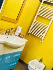 ein gelbes Badezimmer mit einem Waschbecken und einem WC in der Unterkunft Villetta con vista mare e parcheggio in Isola del Giglio