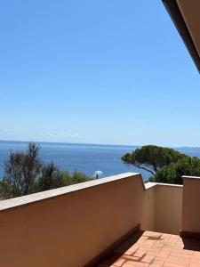 a view of the ocean from the balcony of a house at Villetta con vista mare e parcheggio in Isola del Giglio