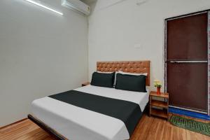 Un dormitorio con una cama grande y una ventana en OYO Flagship Hotel Blue Moon en Patna