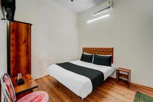 a bedroom with a large bed with black and white sheets at OYO Flagship Hotel Blue Moon in Patna