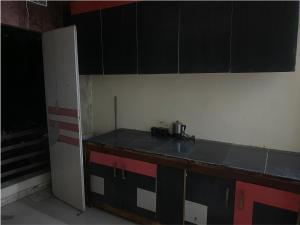 uma cozinha com bancada e armários pretos em My Space em Agra