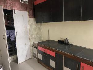 uma cozinha com armários pretos e uma bancada em My Space em Agra