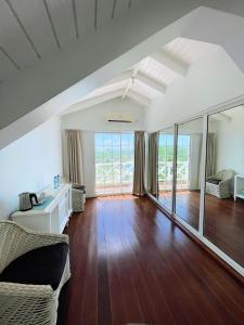 a living room with a couch and wooden floors at Bay House Grenada in Belmont