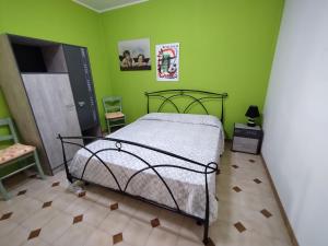 a bedroom with a bed and a green wall at Casa Marilù in Alghero