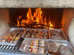 eine Gruppe von Tabletten mit Lebensmitteln in einem Ofen in der Unterkunft Casa Rossa al Lago - Apt Terrazza in Spinone Al Lago