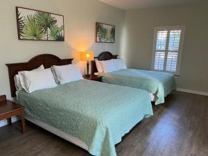 阿兰瑟斯港Seashell Village Resort near the beach with kitchens的有两张床和一张桌子的酒店房间