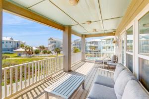 - une terrasse couverte avec un canapé et des chaises sur un balcon dans l'établissement Salty Kisses, à Île Padre