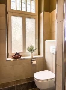 La salle de bains est pourvue de toilettes et d'une fenêtre. dans l'établissement Exklusives Apartment ZOO, à Leipzig