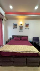 ein Schlafzimmer mit einem großen Bett mit lila Kissen in der Unterkunft Namoh studio and apartment in Ghaziabad