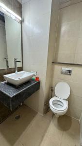ein Badezimmer mit einem weißen WC und einem Waschbecken in der Unterkunft Namoh studio and apartment in Ghaziabad