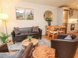 a living room with leather furniture and a table at Reubens Cottage in Barnstaple