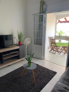 sala de estar con sofá, TV y mesa en Tigili, en Capesterre-Belle-Eau