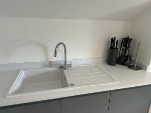 eine Küchenspüle mit einem Wasserhahn auf der Theke in der Unterkunft El Murrino Apartments in Bournemouth + 31 Fotos
