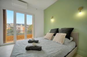 um quarto com uma cama e uma janela grande em Téry - Terrasse - Moderne - VCA em Cannes