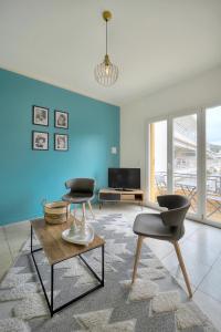 uma sala de estar com uma parede azul e duas cadeiras em Téry - Terrasse - Moderne - VCA em Cannes