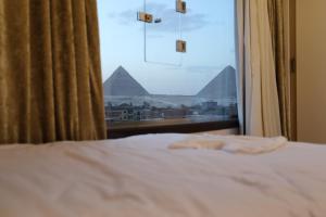 Un pat sau paturi într-o cameră la Pyramids heart view hotel