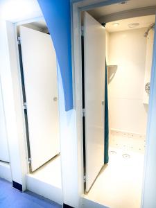 two glass doors in a closet with a blue wall at Castle Rock Hostel - Adults Only in Edinburgh