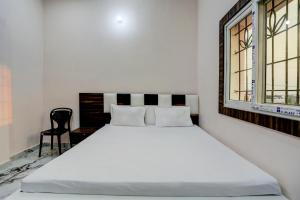 uma cama branca num quarto com uma janela em Super OYO Shivansh banquet and hotel em Dhanbad