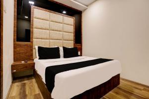 a bedroom with a large white bed with black pillows at OYO Flagship Hotel Ashirwad Inn in Mumbai