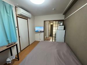 a small room with a bed and a refrigerator at 玉藻藤塚町 in Takamatsu