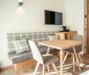 ein Wohnzimmer mit einem Tisch und einem Sofa in der Unterkunft Vivi Suites&Spa Molveno in Molveno