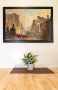 a painting hanging on a wall with a potted plant at Gull Lake Lodge in June Lake