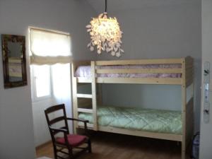 1 dormitorio con litera y lámpara de araña en Maison En Pierres Proche Agnac en Firmi