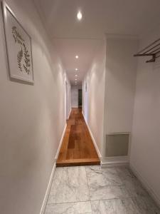 un corridoio con pareti bianche e pavimento in legno di Luxury Apartment In City a Göteborg