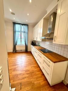 una cucina con armadietti bianchi e pavimenti in legno di Luxury Apartment In City a Göteborg