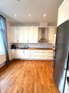una cucina con armadietti bianchi e pavimenti in legno massello di Luxury Apartment In City a Göteborg