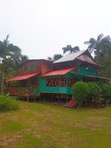 una casa con un edificio rojo y verde en Hostal Búho Amazonas tours, en Leticia