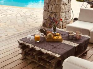uma mesa com uma cesta de frutas e sumo de laranja em Jolie villa en pierre em Callian