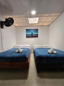 2 camas en una habitación con TV en la pared en Espacioso Apartamento En Circunvalar Por Parceros Group, en Pereira