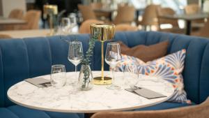 a table with wine glasses on a blue couch at HotelVFjorden in Lemvig