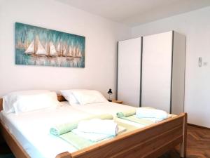 a bedroom with a large white bed with two pillows at APARTMAN GLORIA in Krk