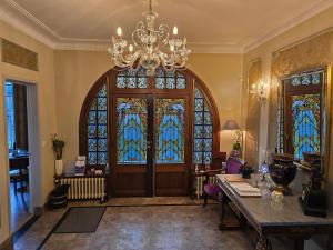 バイユーにあるル カステル ゲストハウスのステンドグラスの大きなドアが付いた広い客室です。
