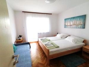 a bedroom with two beds and a large window at APARTMAN GLORIA in Krk