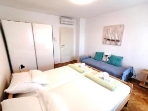 a small room with two beds and a couch at APARTMAN GLORIA in Krk