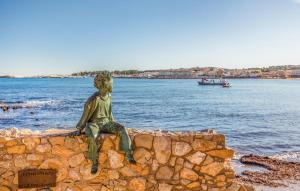 una estatua de un hombre sentado en una pared junto al agua en 2 Bedroom Lovely Apartment In L'escala, en L'Escala 18 fotos más