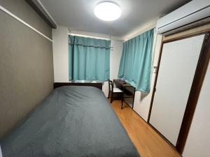 a small bedroom with a bed and a window at 玉藻藤塚町 in Takamatsu