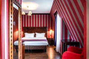 a bedroom with a bed with red and white stripes at Villa Panthéon in Paris