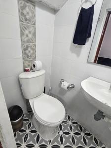 a white bathroom with a toilet and a sink at Acogedor Apartamento En La Circunvalar By Parceros Group in Pereira