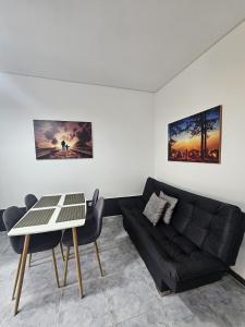 a living room with a black couch and a table at Acogedor Apartamento En La Circunvalar By Parceros Group in Pereira