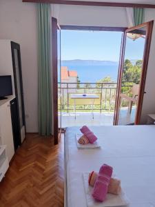 a bedroom with a bed with a view of the ocean at Apartments Slaven in Podgora